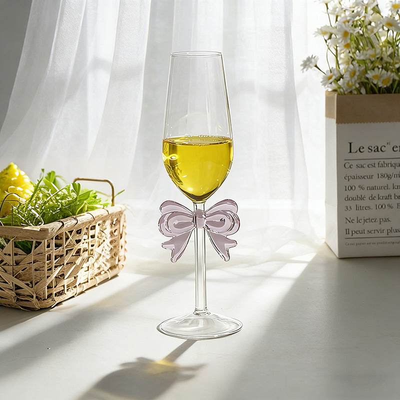 Bowknot stemmed glass with beverage and home decor background