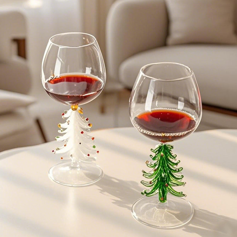 Christmas tree stemmed glasses with beverage displayed on a bright dining table