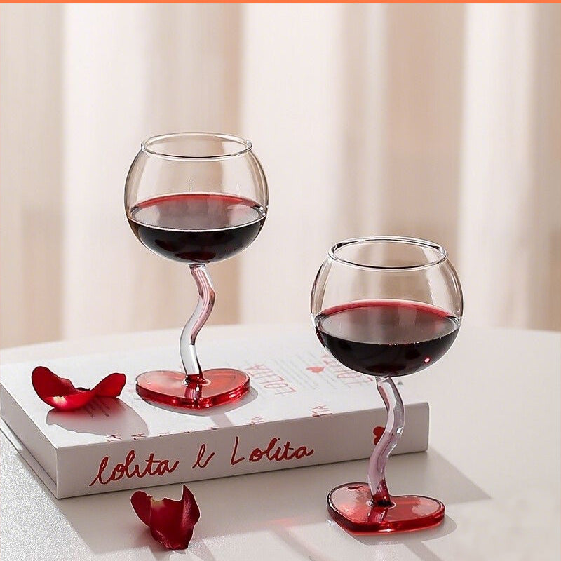 Heart design stem glasses with beverage displayed on elegant table setting