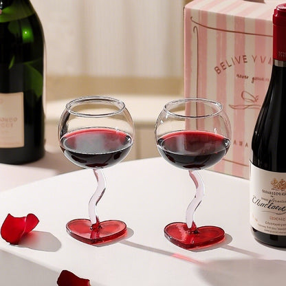 Heart design stem glasses with beverage on romantic table arrangement