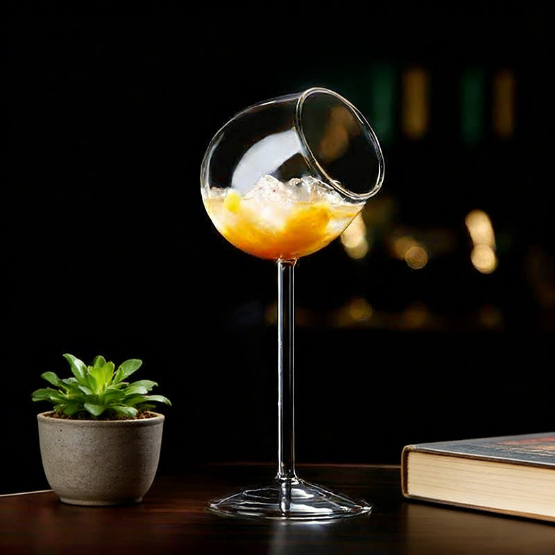 Tilted rim glass with citrus beverage and decorative table arrangement