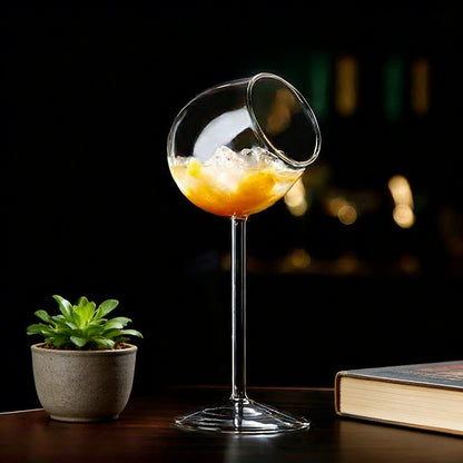Tilted rim glass with citrus beverage and decorative table arrangement