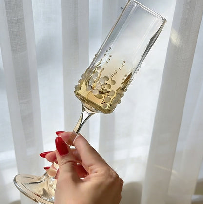 Hand holding decorative vine pattern stemmed glass showing transparent glass details